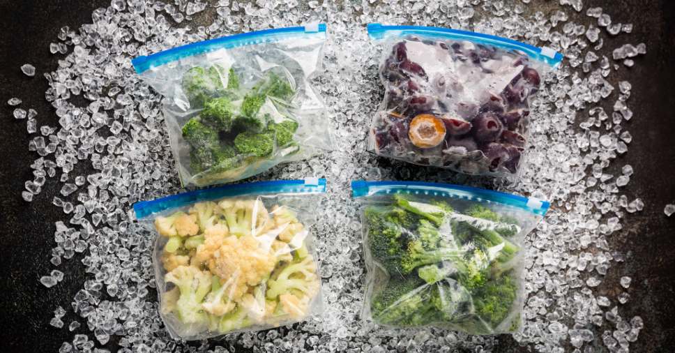 Sacos plásticos com vegetais e frutas sobre gelo ilustram o congelamento rápido industrial.